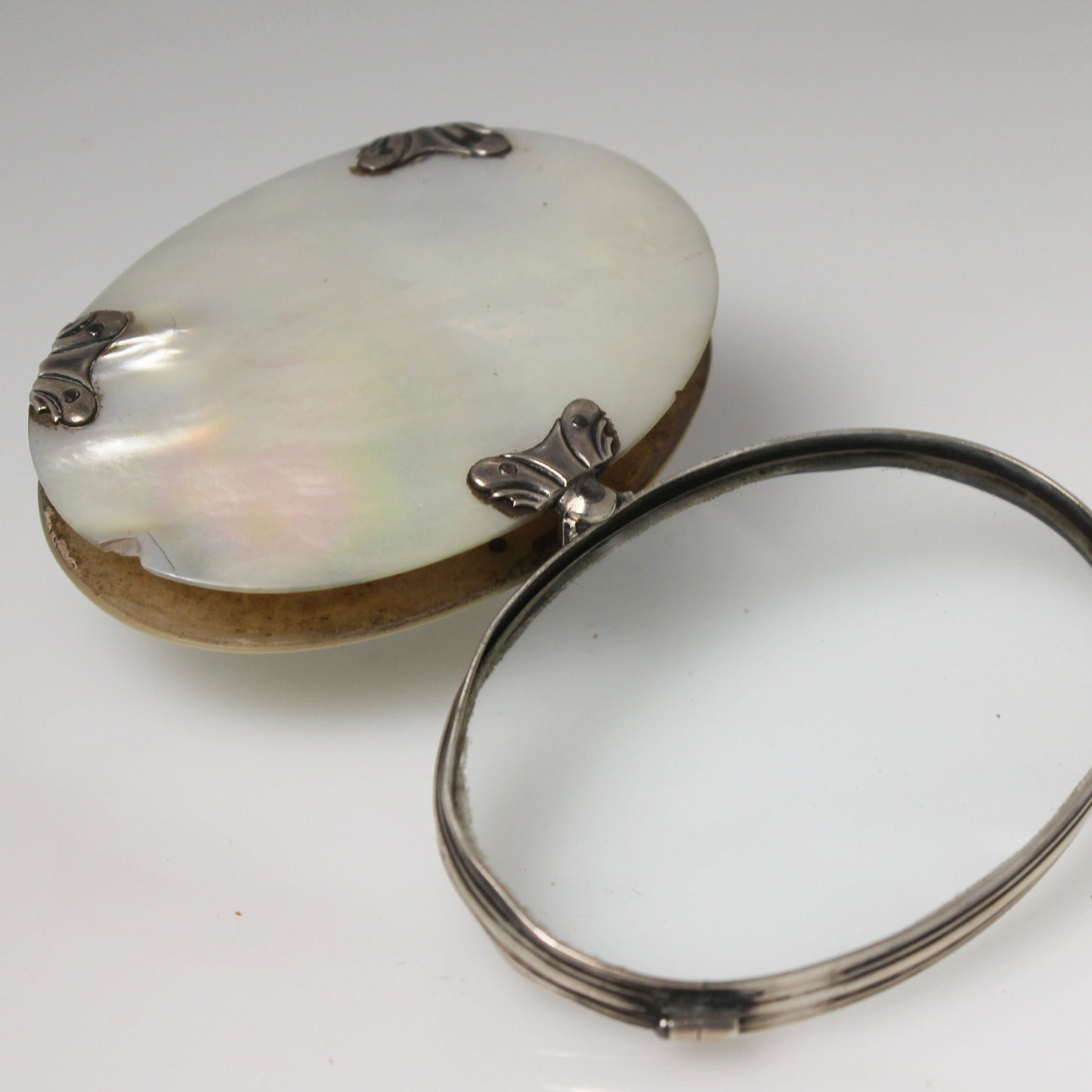 Lupa de bolsillo plegable en nácar y plata. Francia, finales s. XIX – pps. s. XX