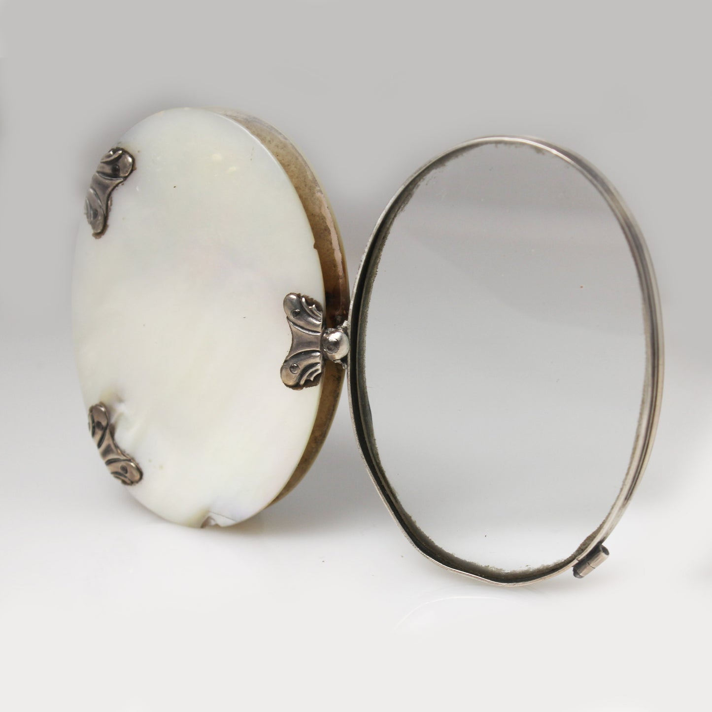 Lupa de bolsillo plegable en nácar y plata. Francia, finales s. XIX – pps. s. XX