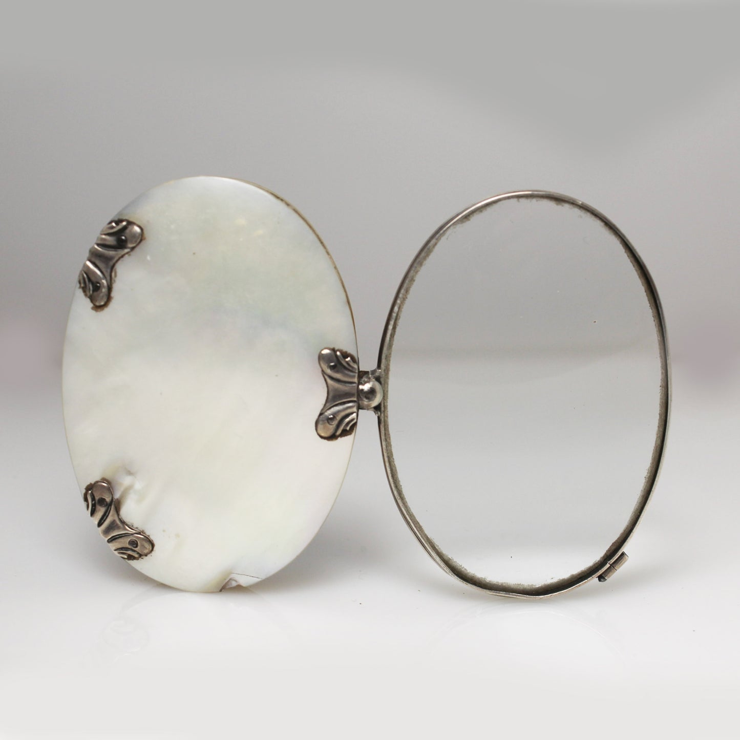 Lupa de bolsillo plegable en nácar y plata. Francia, finales s. XIX – pps. s. XX