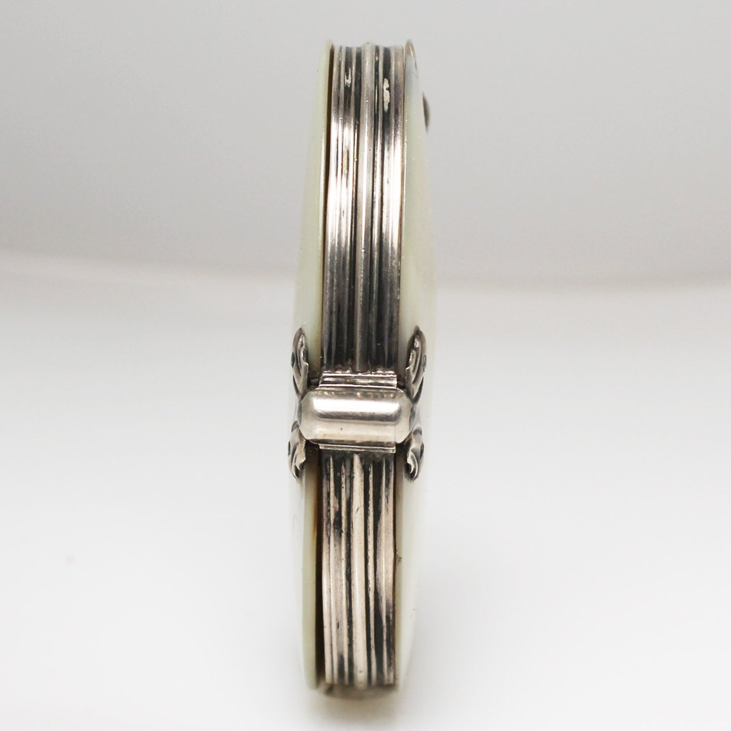 Lupa de bolsillo plegable en nácar y plata. Francia, finales s. XIX – pps. s. XX