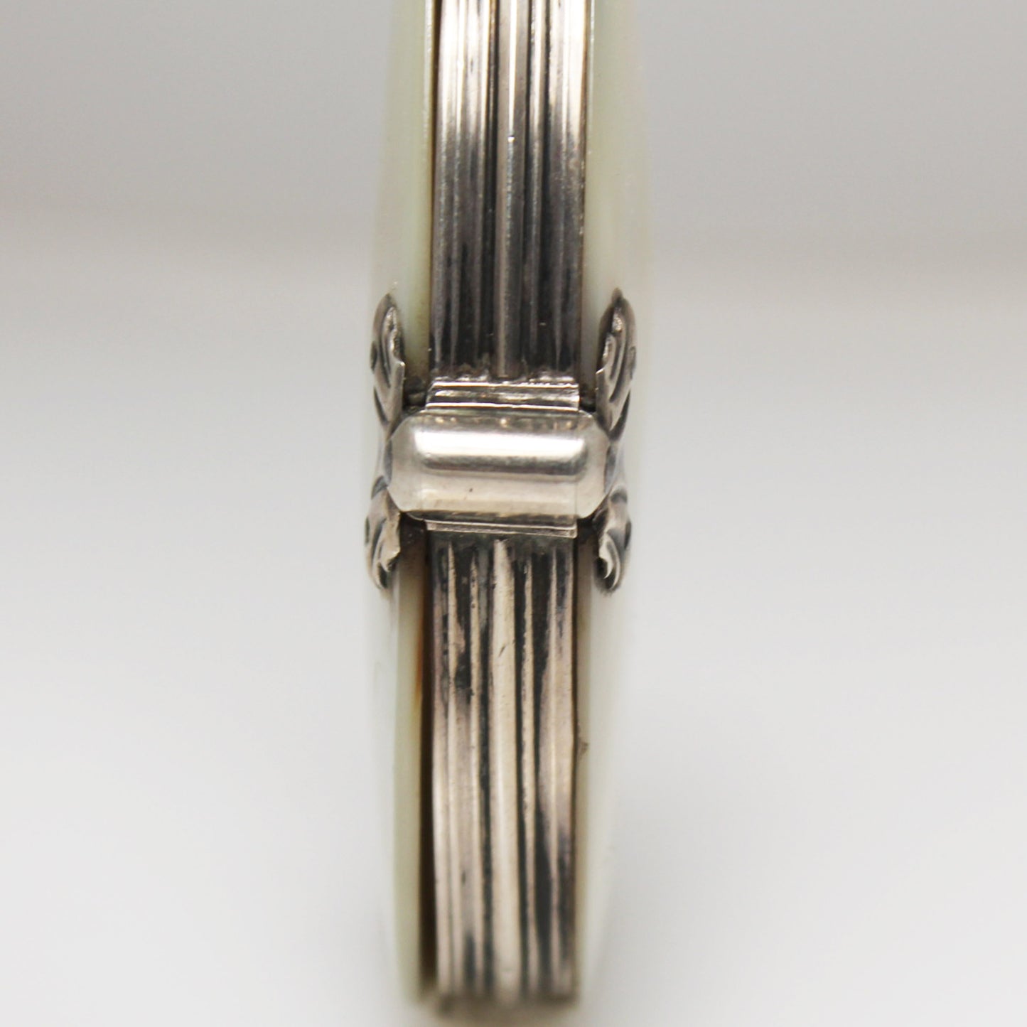 Lupa de bolsillo plegable en nácar y plata. Francia, finales s. XIX – pps. s. XX